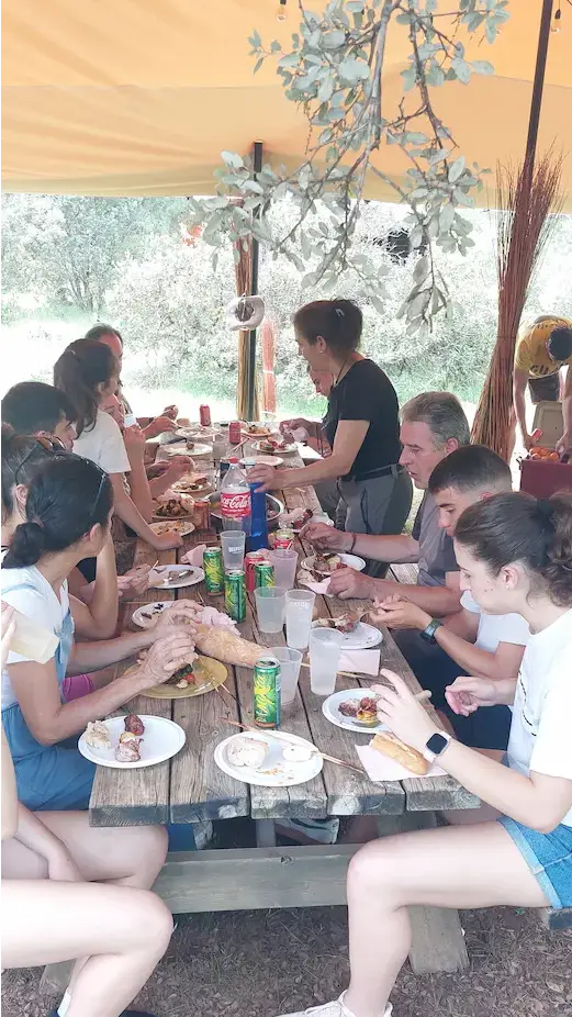 Familia comiendo en el campo, en unas mesas de madera en las cabañas llano de los conejos